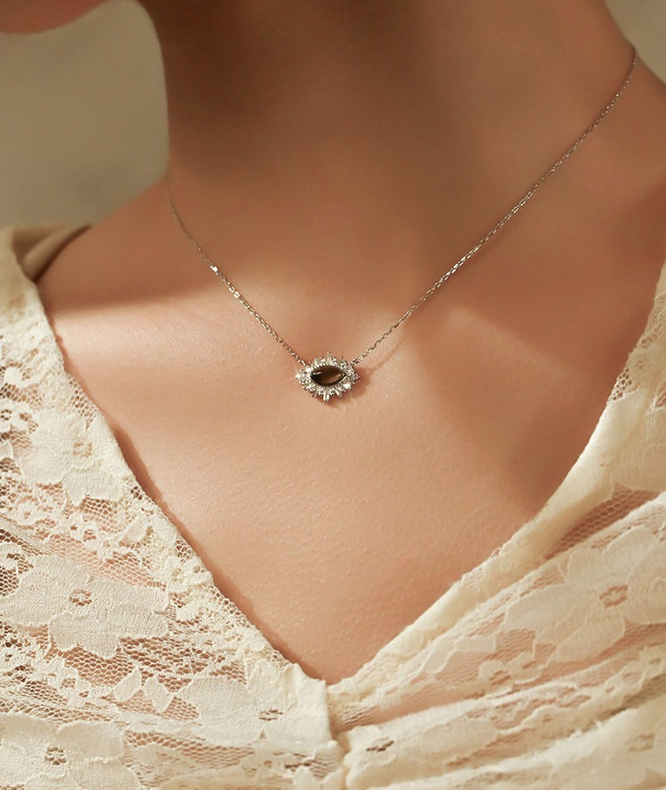 Necklace with a pendant worn by a person in a lace garment