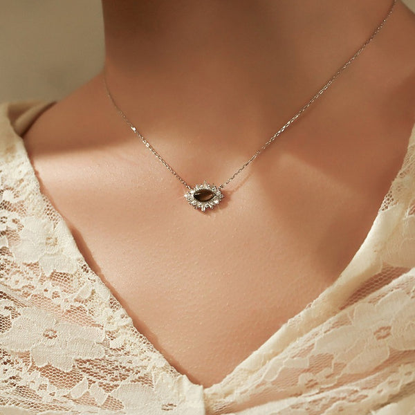 Necklace with a pendant worn by a person in a lace garment