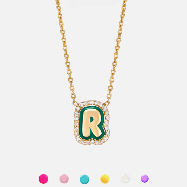 Gold necklace with a green and gold letter 'R' pendant on a white background