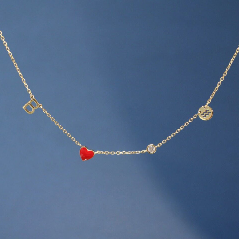 Gold necklace with a red heart pendant on a blue background