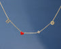 Gold necklace with a red heart pendant on a blue background