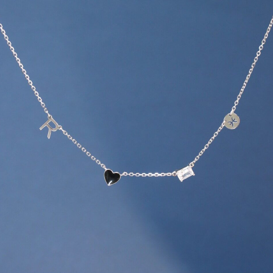 Silver necklace with heart and square pendant on a blue background