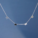 Silver necklace with heart and square pendant on a blue background
